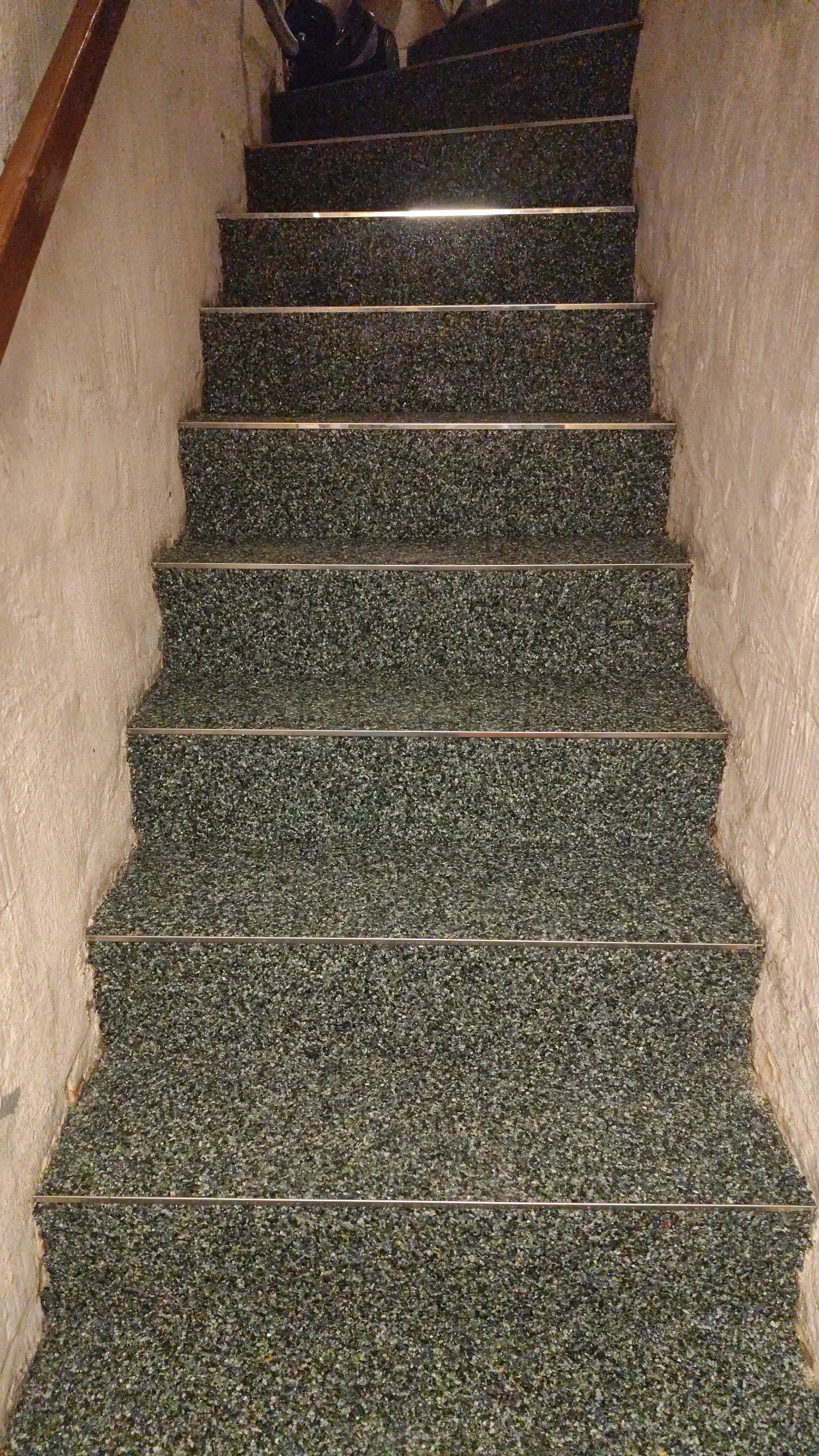Treppe mit Steinteppichbelag, gut beleuchtet und ordentlich gestaltet