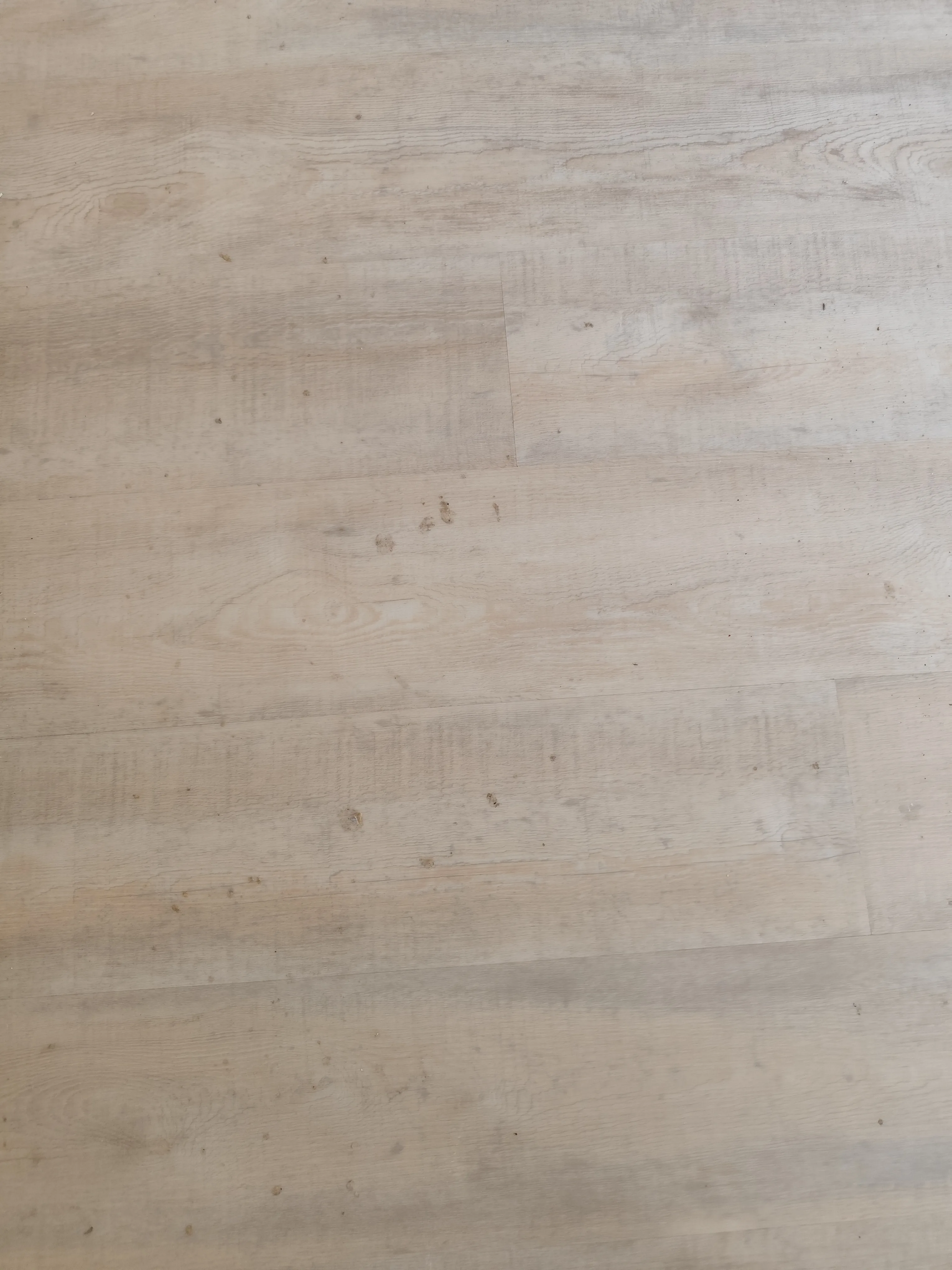 Sicht auf einen Epoxidharzboden mit hellen Holzoptik und sichtbaren Gebrauchsspuren