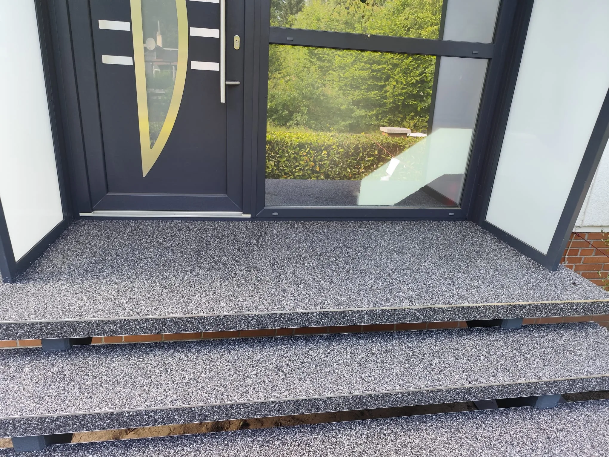 Steinteppich Treppe mit modernem Design vor einer Eingangstür